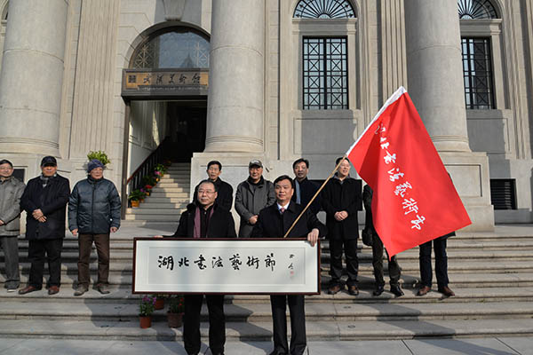 监利县委副书记、政协主席陈孝俊（右）代表第五届湖北书法艺术节承办单位接旗、接牌