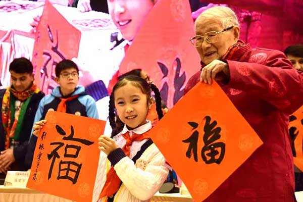 104岁的顾振乐先生与九岁的小书法家代表曹恺诺互赠福字